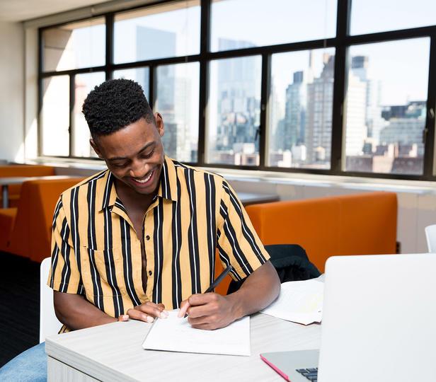 student sitting at desk in residence hall lounge